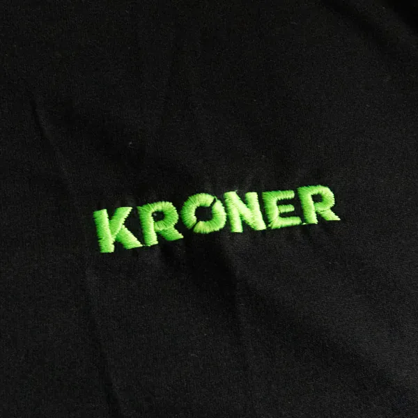 Chomba negra con logo Kroner bordado en verde